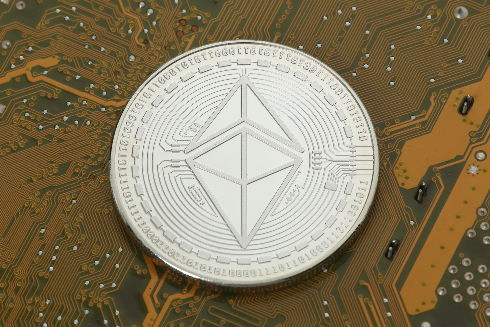 Silver Ethereum coin resting on a circuit board, illustrating the ETH gas token used on both Arbitrum and zkSync