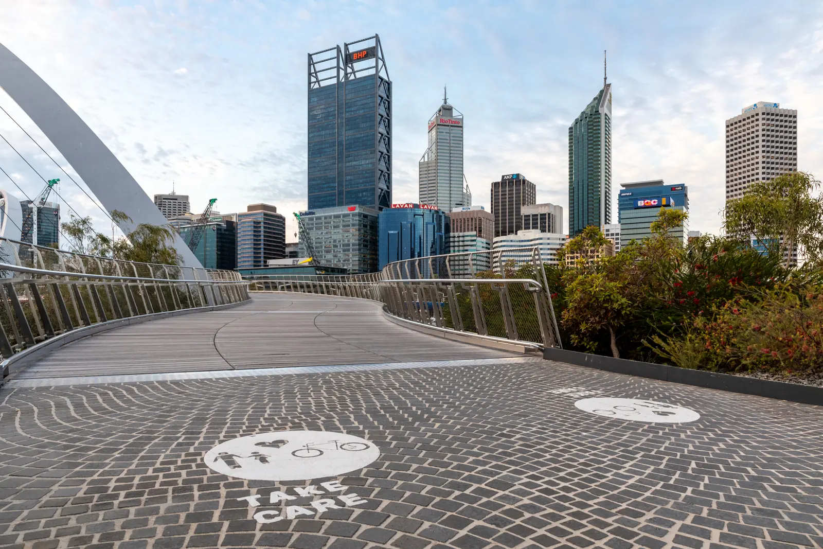 Curved pedestrian bridge leading toward a city skyline, illustrating the best Solana bridge options for moving crypto to Solana