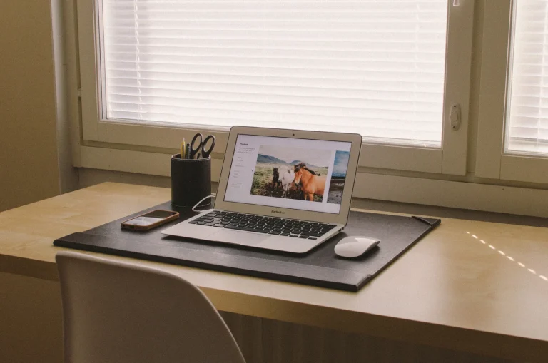 Laptop and smartphone on a tidy desk by a window, illustrating a guide to the best USDT wallets