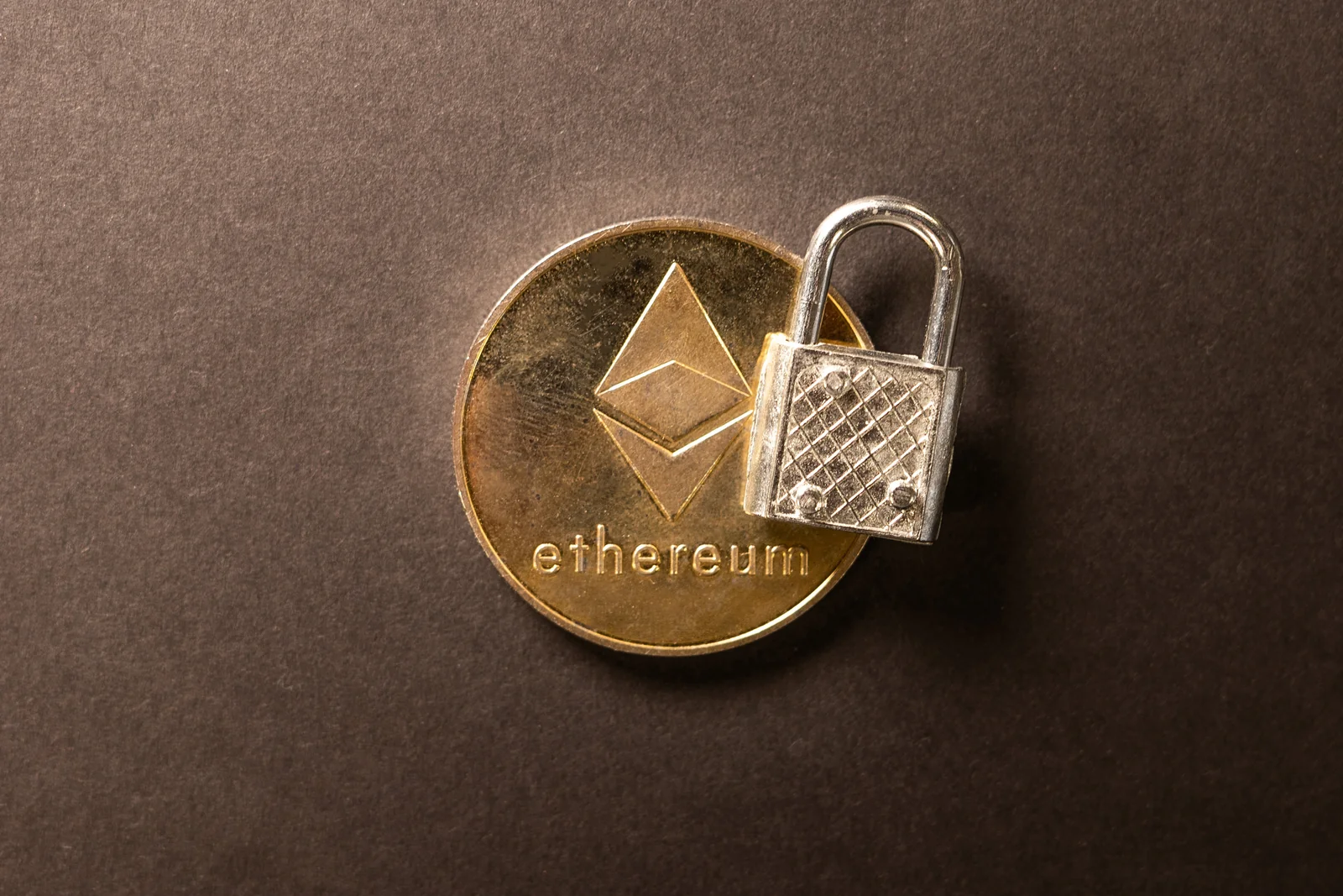 Ethereum coin with a small padlock resting on it, illustrating a guide to the best wallets for DeFi