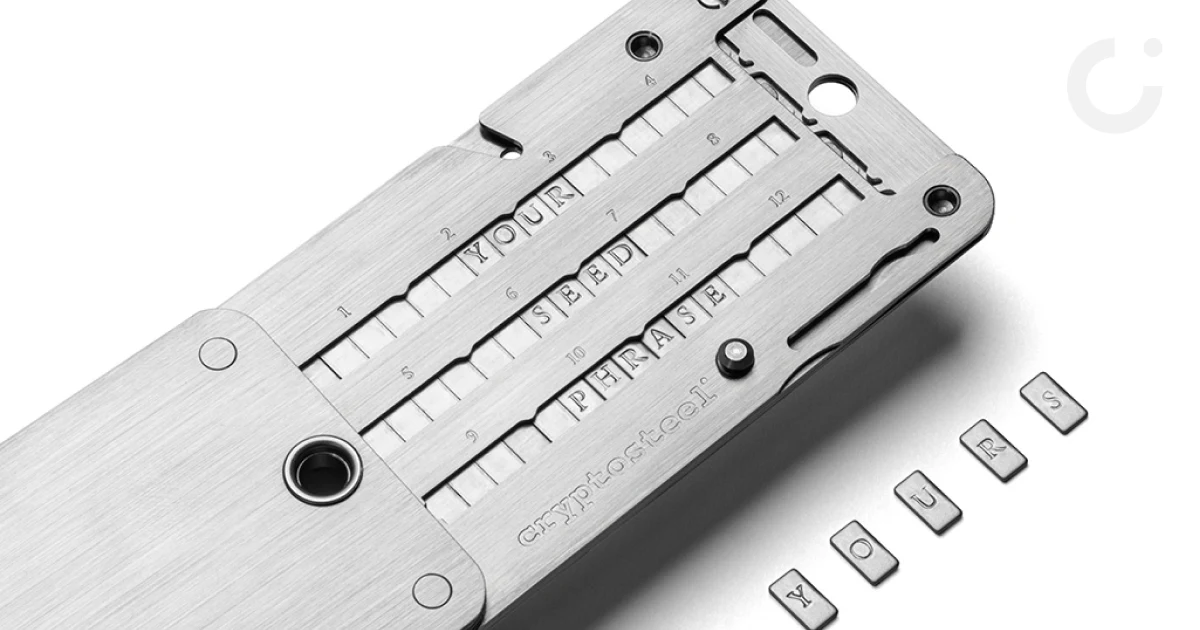 Cryptosteel Cassette in brushed stainless steel with character tiles spelling out a seed phrase, loose letter tiles beside it
