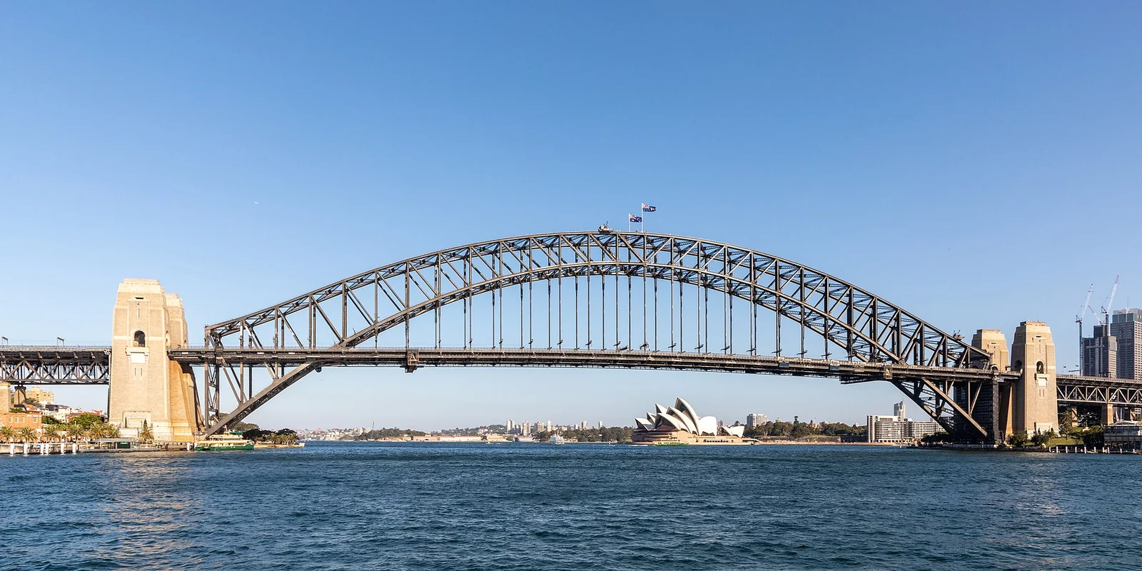 Steel arch bridge over blue water under a clear sky, illustrating how to bridge ETH to Base