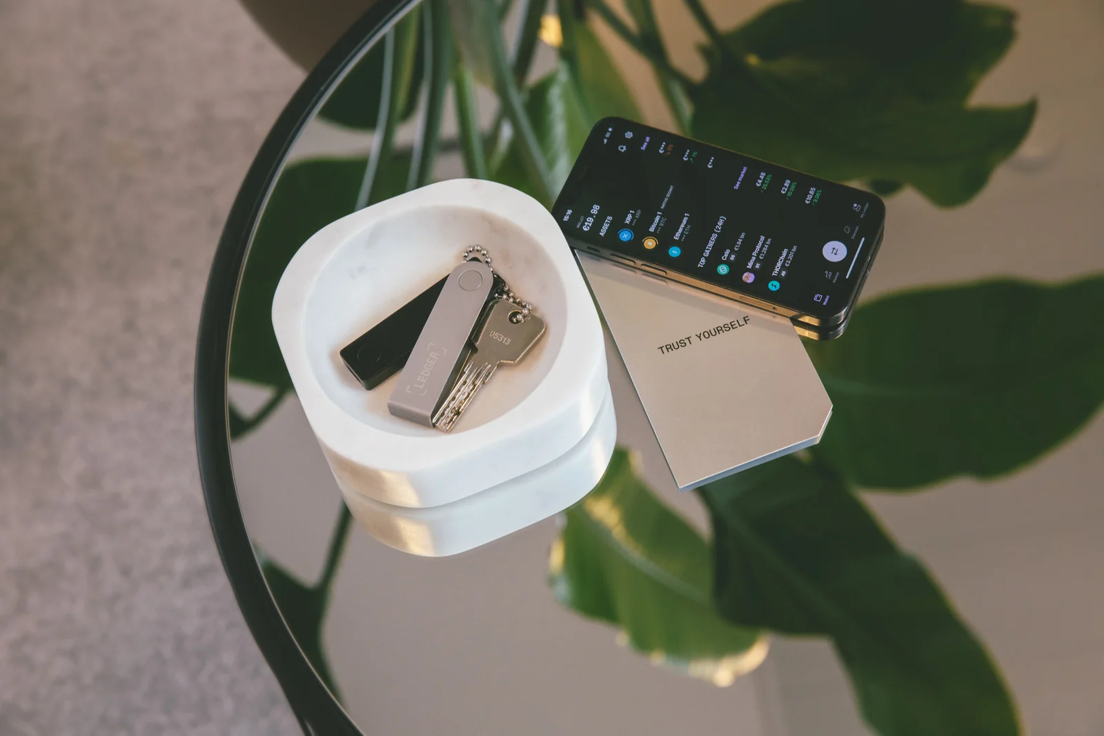 Ledger Nano X on a table next to a smartphone, the pairing route used by the MetaMask mobile app