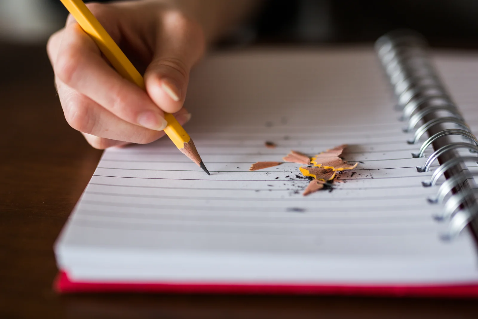 Hand writing in a notebook with a pencil, the way MetaMask advises recording a Secret Recovery Phrase