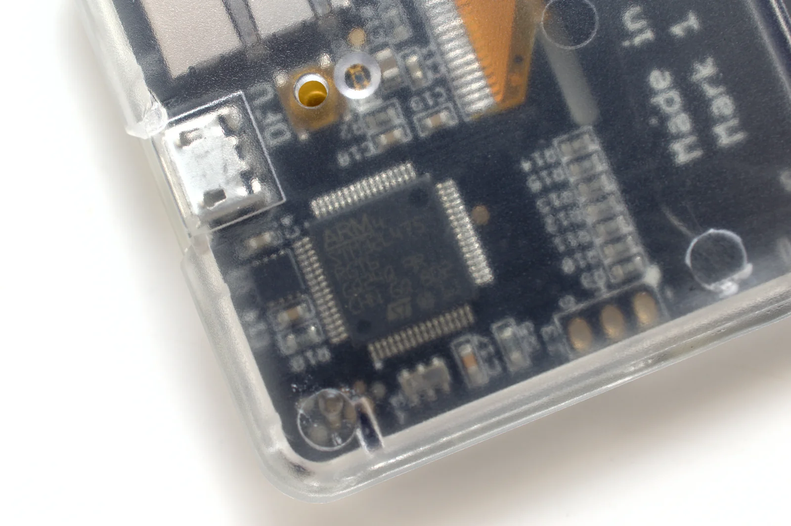 Close-up of the circuit board and chip visible through the clear case of a Coldcard hardware wallet