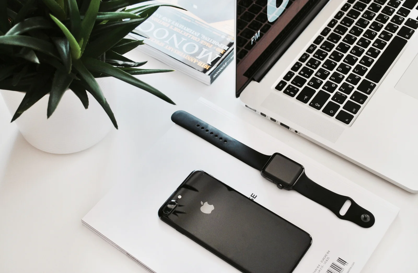 Smartphone and laptop on a white desk, the two places you would run MetaMask or Phantom