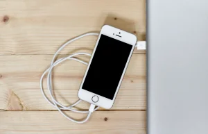 Smartphone and laptop on a light wooden desk, the devices you run Phantom and Solflare on