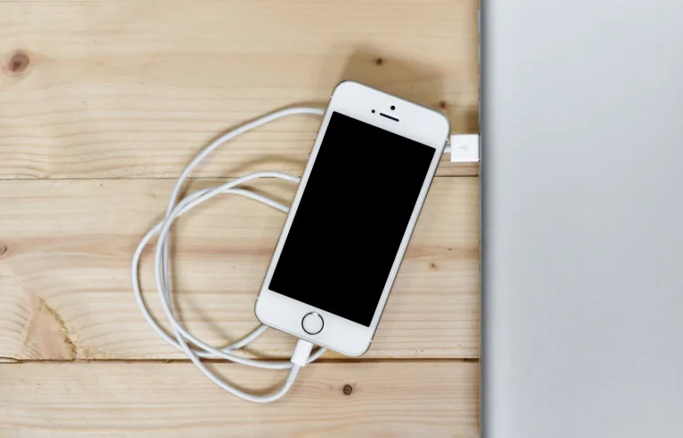 Smartphone and laptop on a light wooden desk, the devices you run Phantom and Solflare on