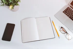 Laptop and smartphone on a white desk, the two devices you run Rabby Wallet and MetaMask on