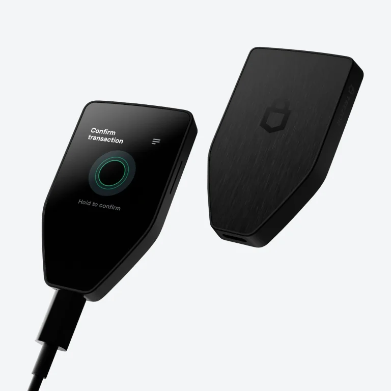 Trezor Safe 5 front and back, with a transaction confirmation prompt on its color touchscreen