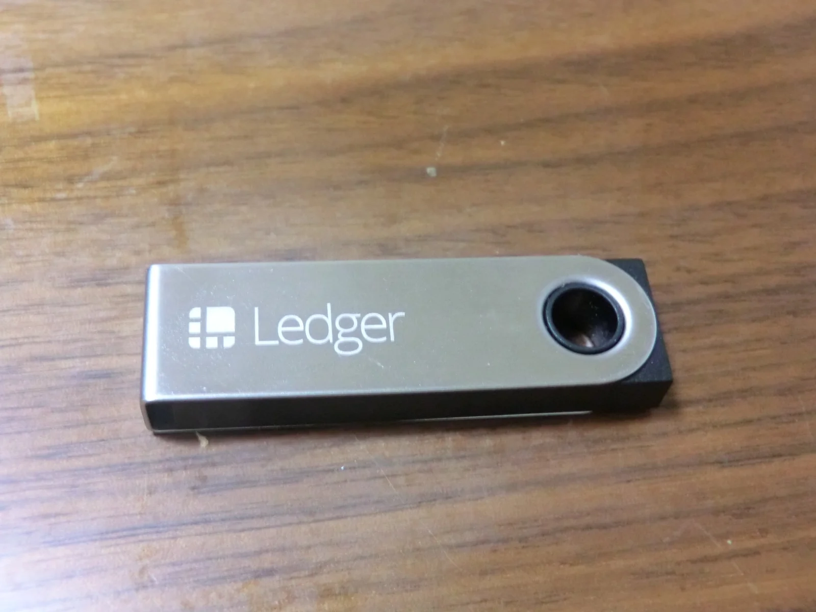 A Ledger Nano S hardware wallet on a desk, a Ledger device of the kind that supports a 25th word passphrase
