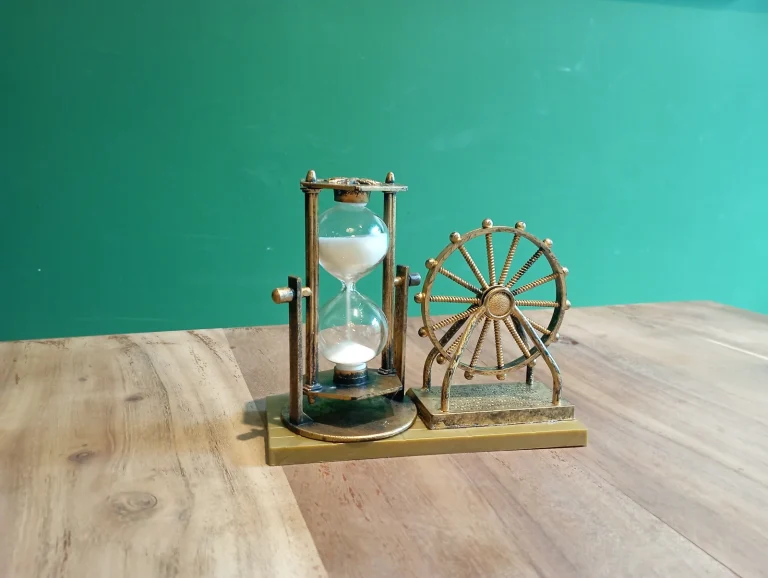 An hourglass with its sand running on a wooden table, a picture of the wait when a crypto transaction is stuck pending